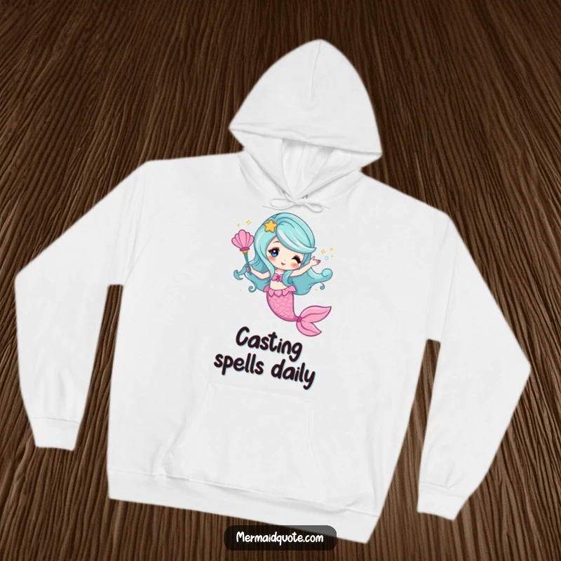Funny hoodie depicting a mermaid creating sparkling magic with a seashell wand, cozy and enchanting.