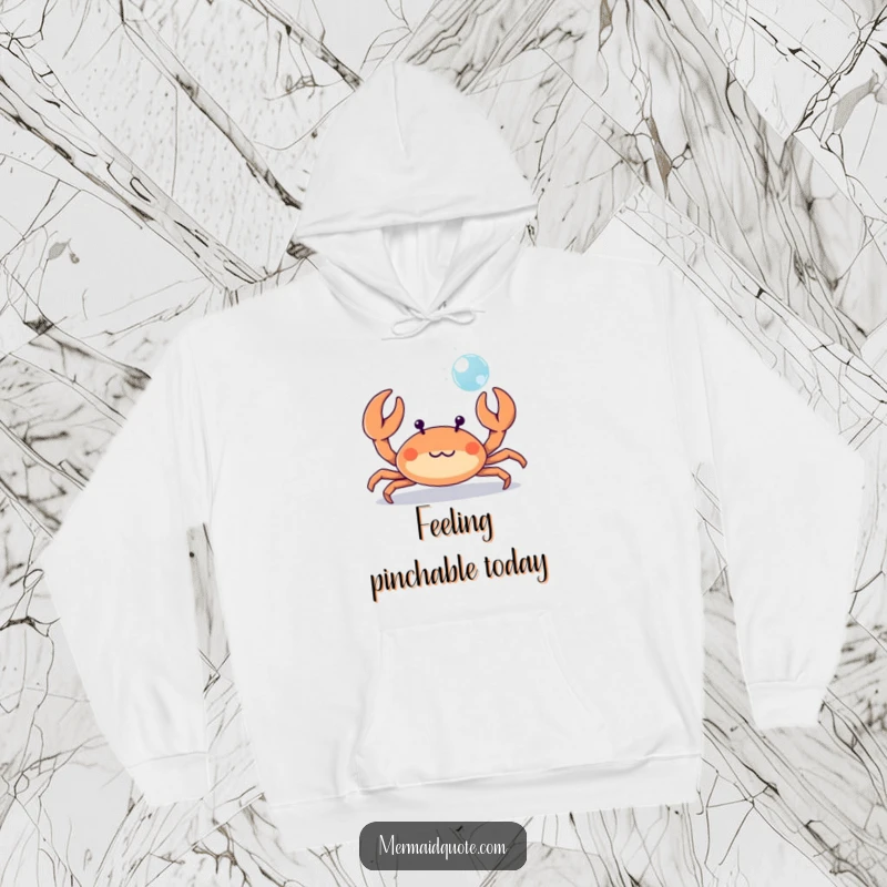 Funny tiny crab playfully waving its tiny claws at a bubble, a warm and humorous hoodie for beachy fun.