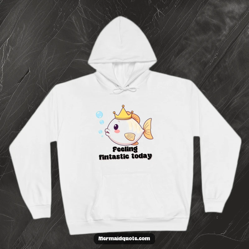 Funny kawaii fish with a gleaming tiny crown, exhaling a cluster of shimmering bubbles, depicted on a warm, comfortable hoodie.