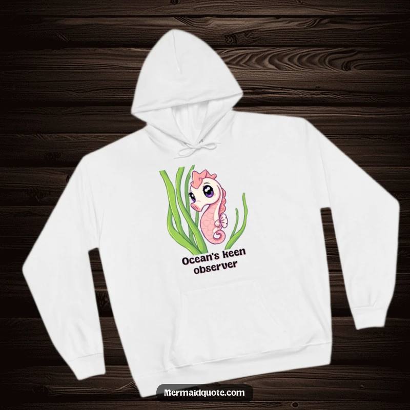 Funny Hoodie of a curious seahorse with wide, sparkling eyes peeking from seaweed, offering warmth and humorous oceanic charm.