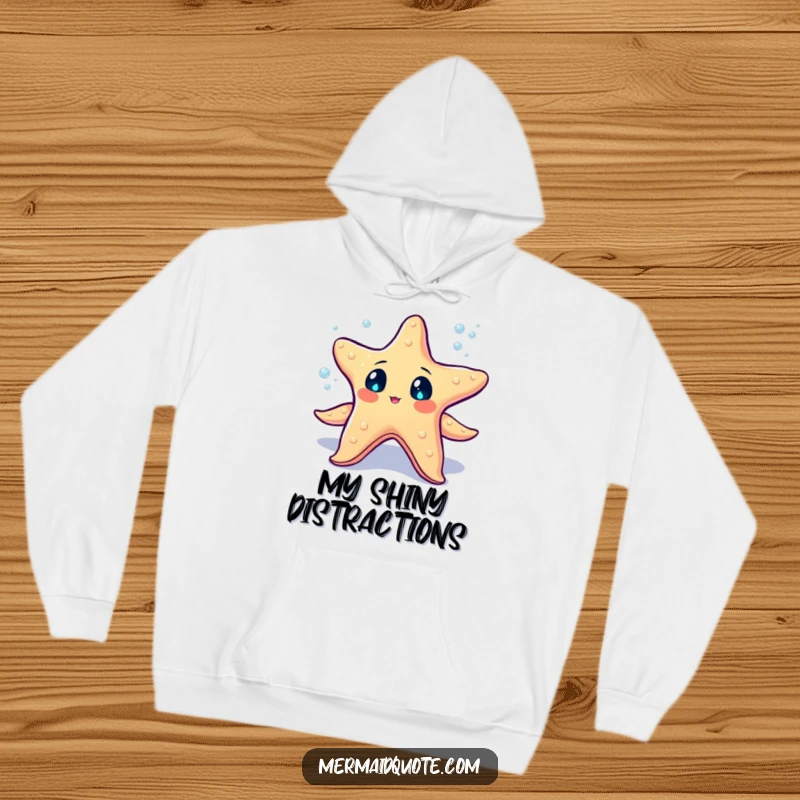 Funny starfish with sparkling eyes juggling tiny glowing sea pearls on a hoodie, comfortable and magical for all.