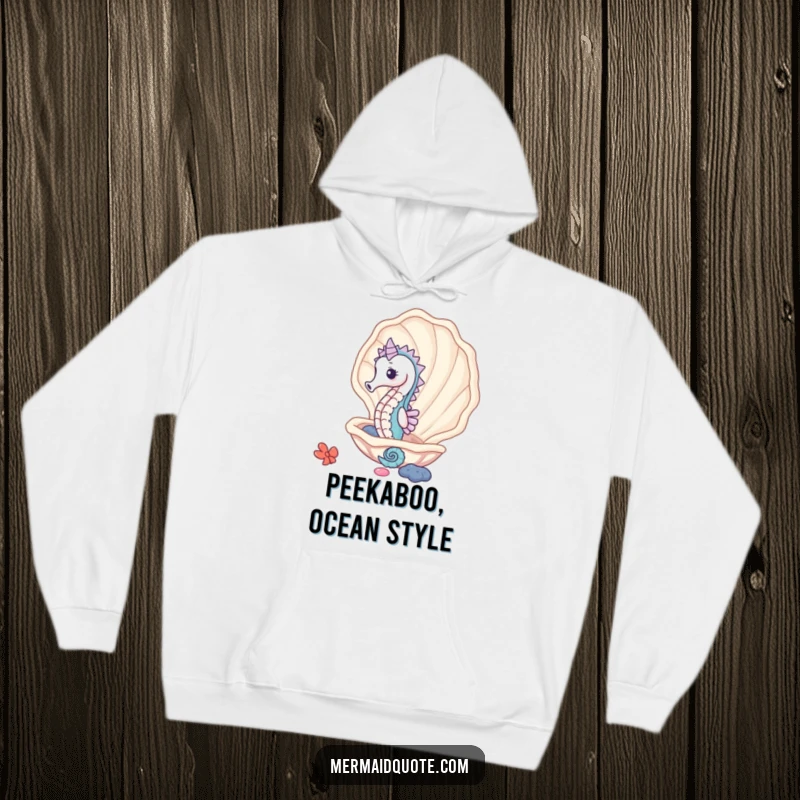 Funny cute seahorse peeking from a giant clam shell, a warm and humorous hoodie for ocean secrets.